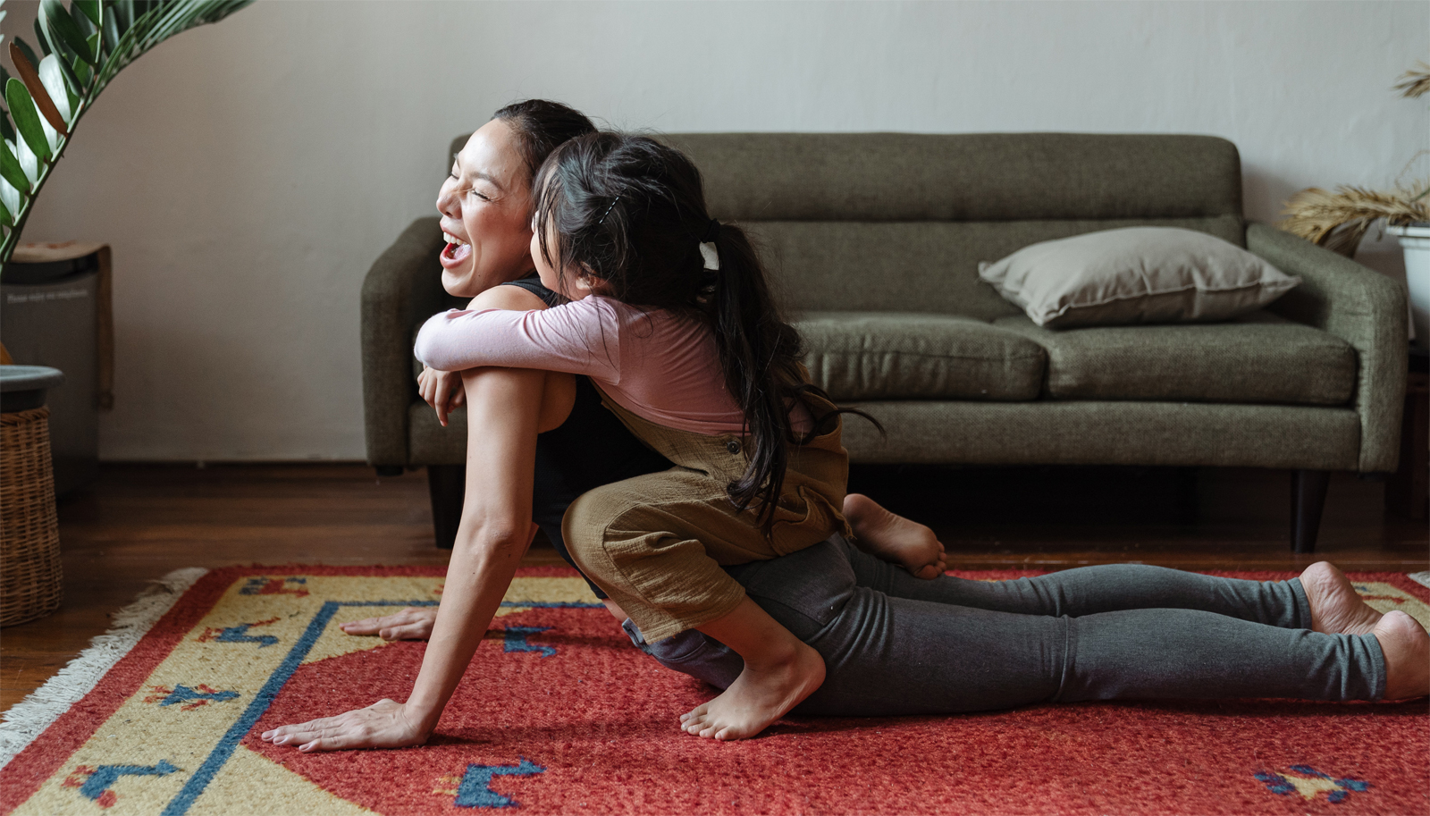 mom yoga with child on her back